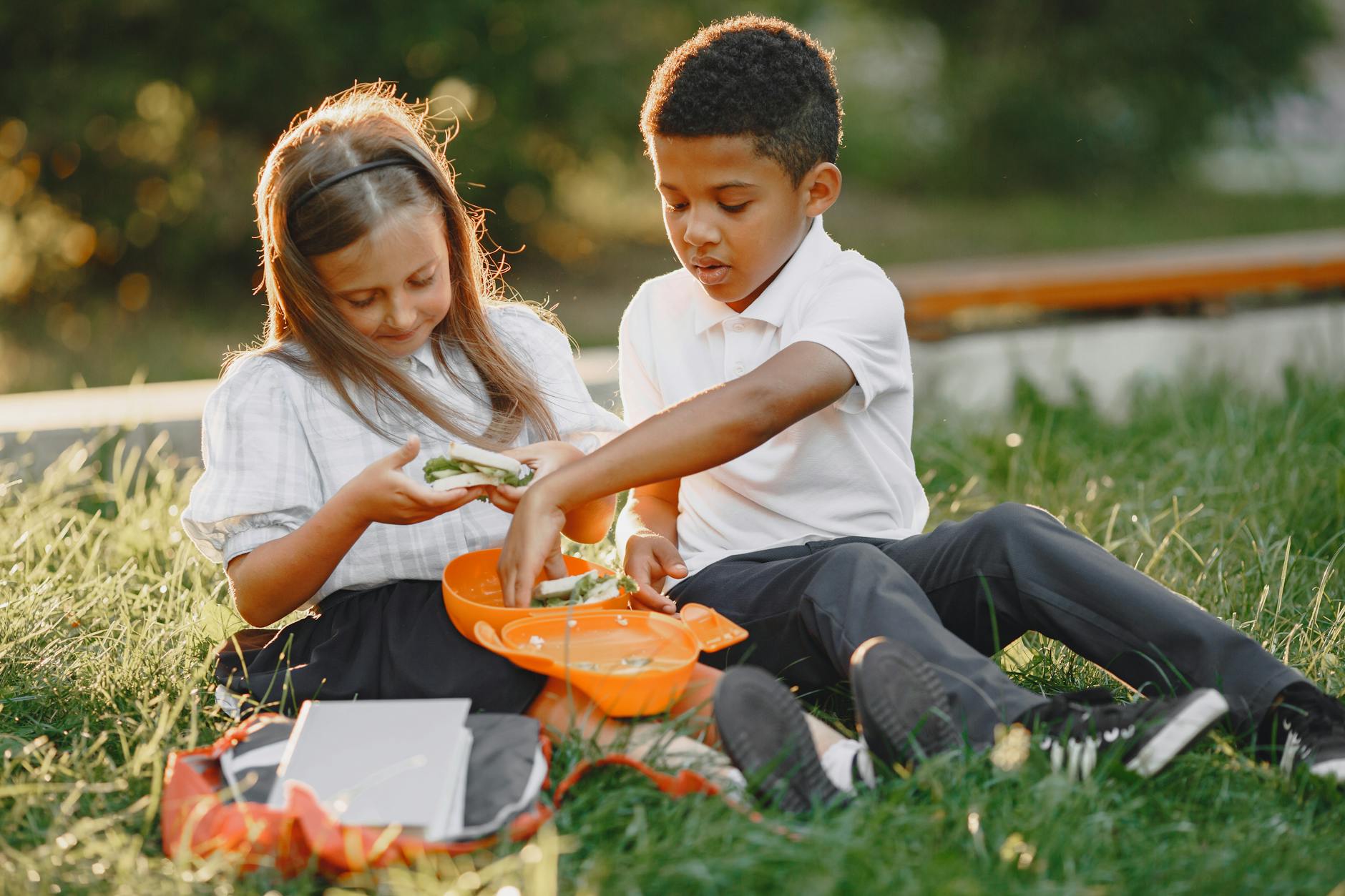 schoolchildren eating lunch on the lawn